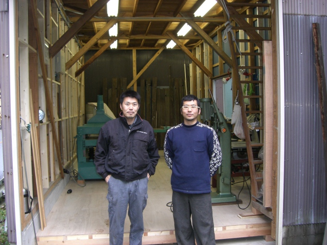 『あつらえ家具製作所　カグマサ』代表　近藤賢様（写真右）と工房入り口にて