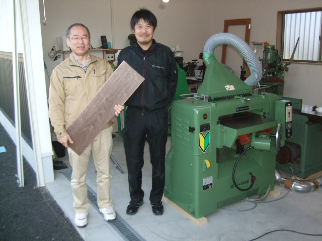 木工房ＹＺのオーナー吉積透さん（左）と購入して頂いた桑原の自動一面鉋盤の前で
