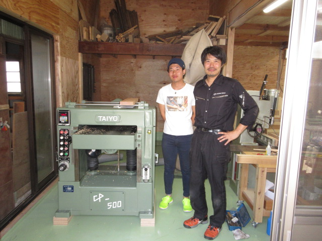 関口家具店の関口隼平さん（左）と、納品させて頂いた太洋製作所のプレナーの前で