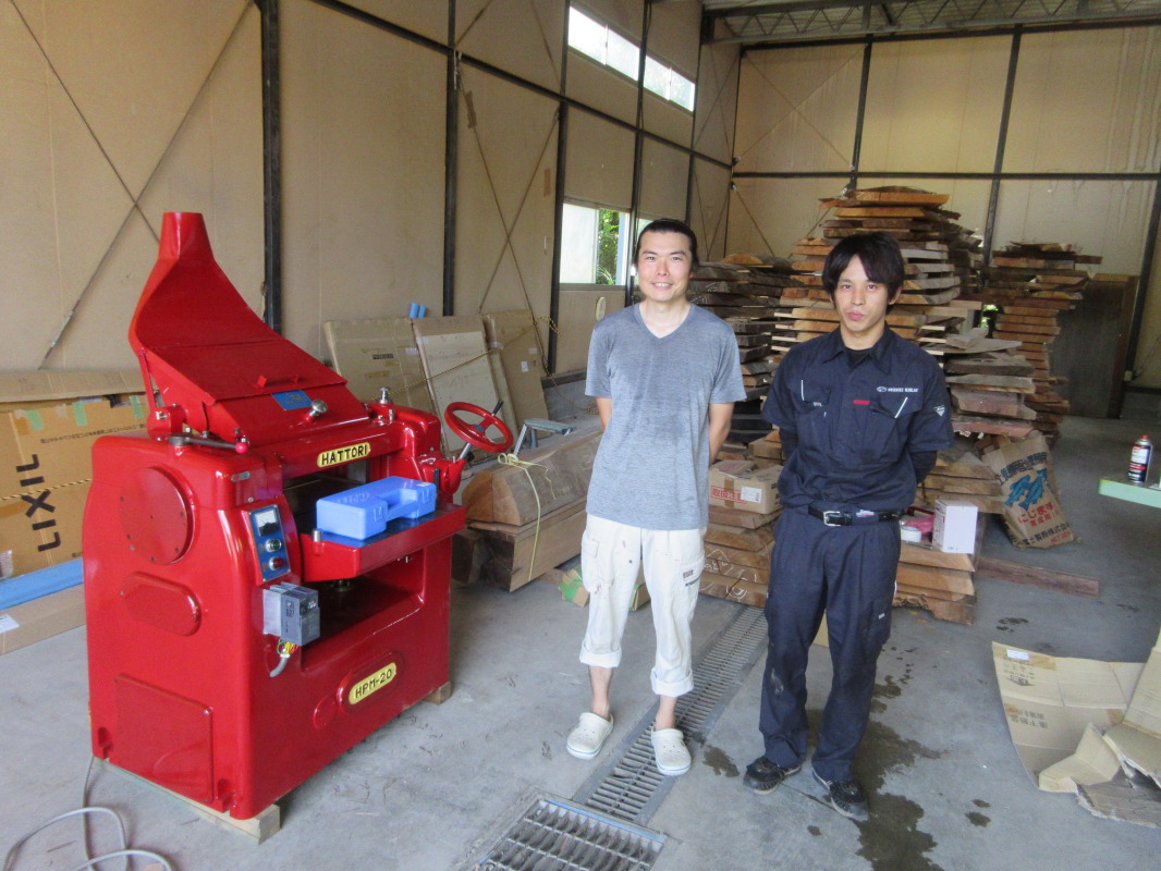 木製道具工房クラフト・ノラの代表渡邊俊輔さん（左）と当社社員の渡邉（右）。今回購入して頂いた特注の深紅の服部自動一面鉋盤の前で