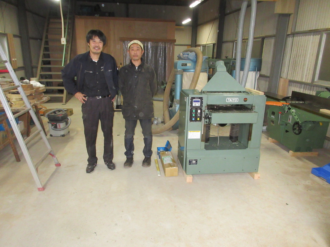 ＭｏｏｎＲｏｕｎｄｓ　ｗｏｏｄｗｏｒｋｓの代表、渡邉崇さん（右）と今回購入して頂いた機械の１台、太洋製作所自動一面鉋盤の横で
